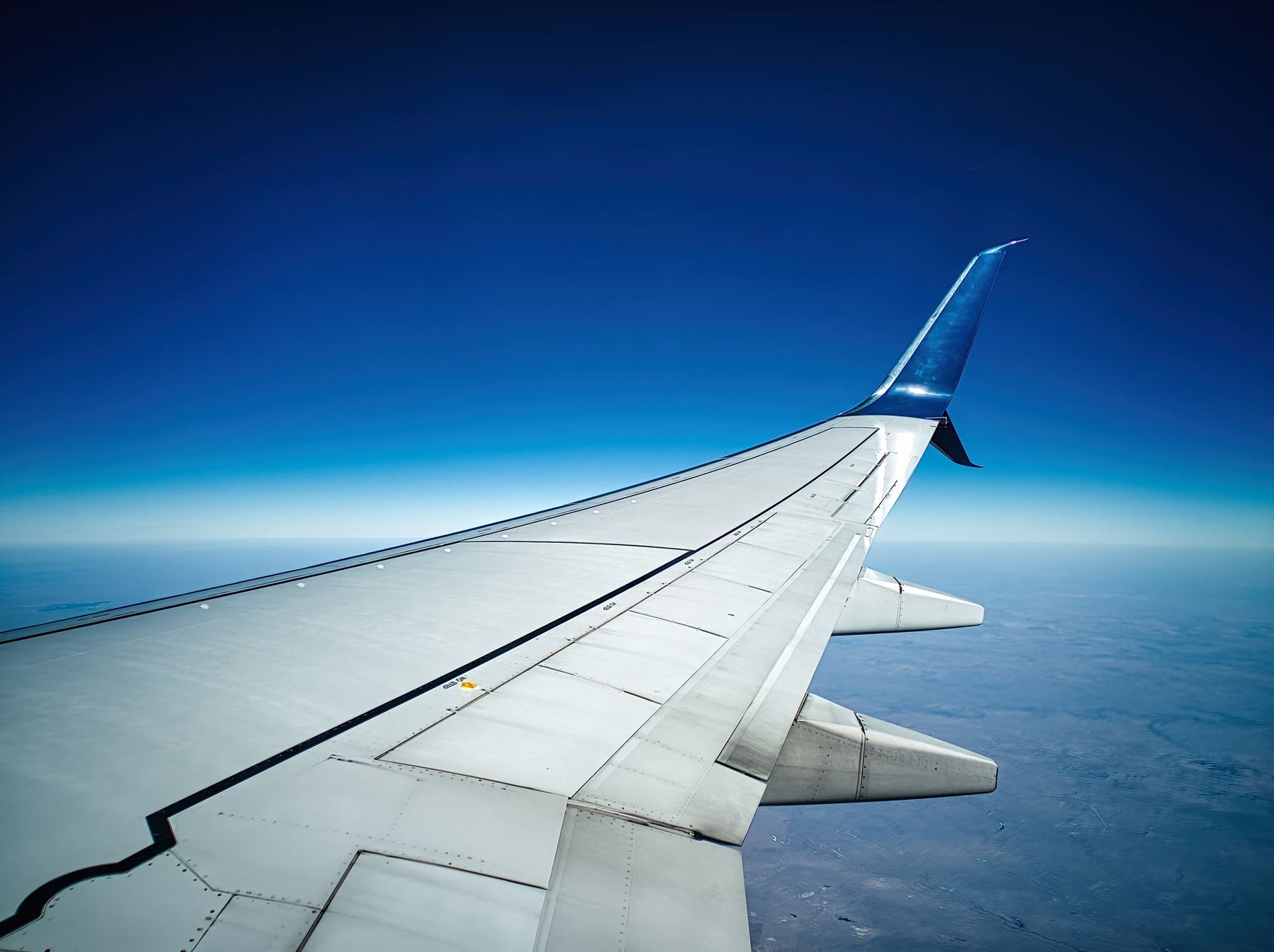 View of an aircraft wing in flight above the clouds